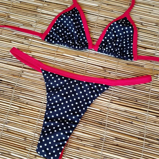 Polka dot bikini with red straps on a woven mat